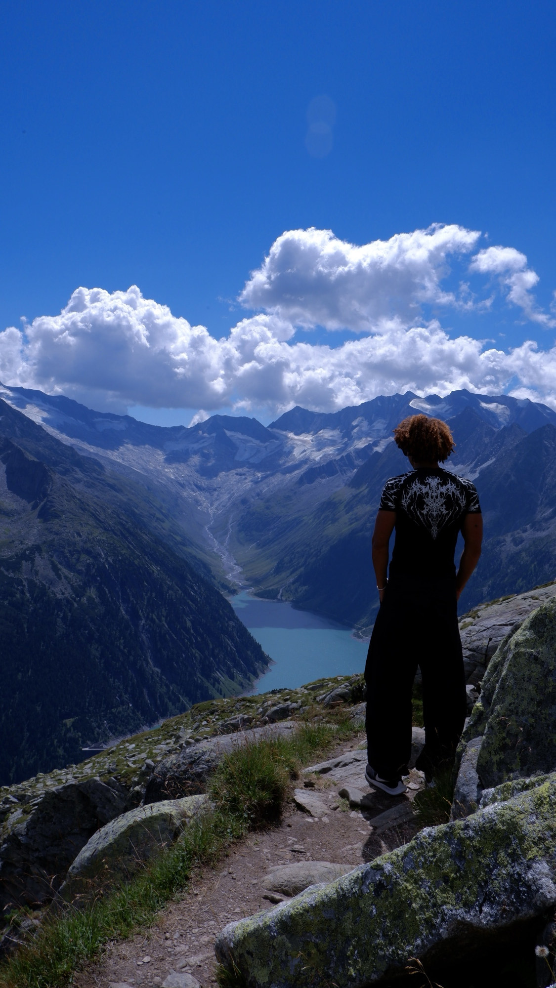 João from behind, looking over a mountain lake